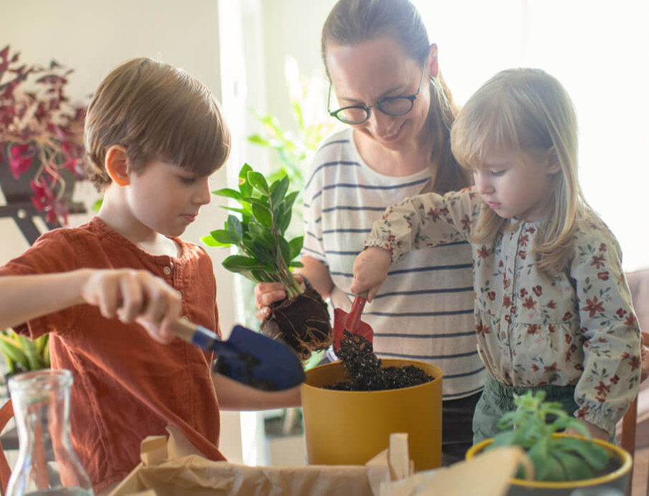 young family putting a plant into a pot